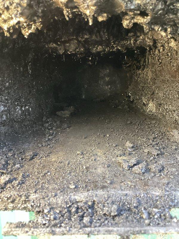 Inspected 25-year-old central wood boiler experiencing airflow issues when door is closed. Identified significant buildup in flue and cleanout areas as confirmed by visual inspection. Checked front door damper, actuator, and inside damper; recommended deep cleaning, chimney stack replacement, and scheduled follow-up consultation to discuss repair options or potential replacement given the unit's age.