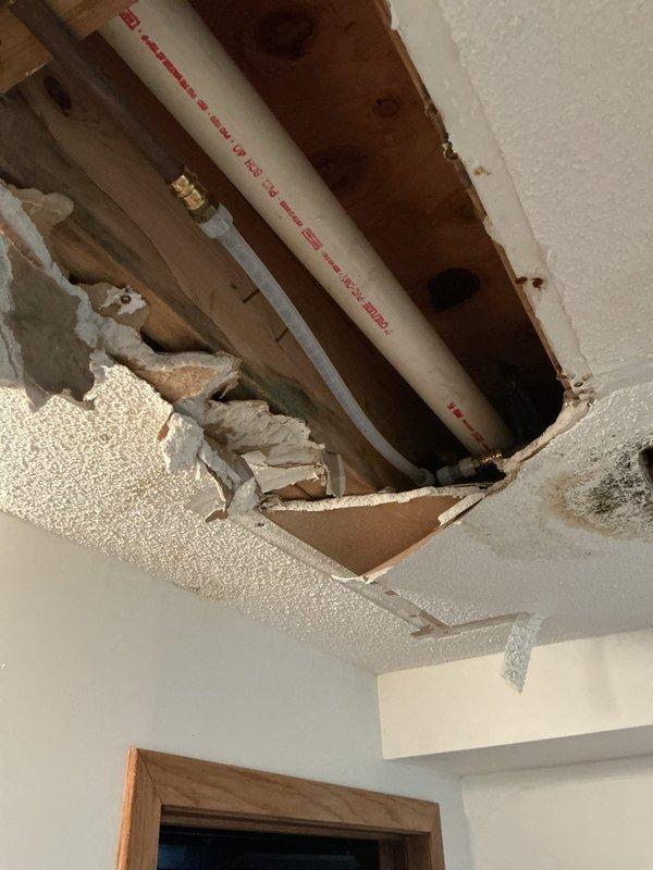 Responded to emergency water leak in basement ceiling where a half-inch copper hot water line had failed. Shut off water supply to prevent further damage, then replaced damaged section of copper pipe with PEX tubing. Reestablished water service, fired up water heater, and replaced toilet angle stop to restore full functionality to the residence's plumbing system.