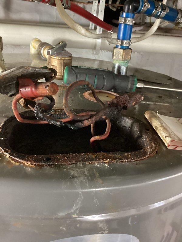 Responded to emergency service call for a 3-year-old, 50-gallon electric water heater with reported electrical burning smell and crackling noises. Upon inspection, identified severely corroded components and melted electrical wiring in the upper compartment. Power was confirmed disconnected for safety. Provided customer with replacement options; awaiting customer decision for installation of new unit. Responded to emergency service call for a 3-year-old, 50-gallon electric water heater with reported electrical burning smell and crackling noises. Upon inspection, identified severely corroded components and melted electrical wiring in the upper compartment. Power was confirmed disconnected for safety. Provided customer with replacement options; awaiting customer decision for installation of new unit.