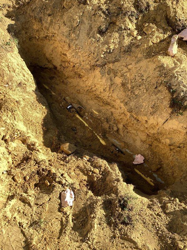 Excavated area to access underground gas line for dryer service. Identified damaged section requiring replacement parts located in Menomonee. Dryer remains non-operational until gas pipe repairs can be completed with proper components.
