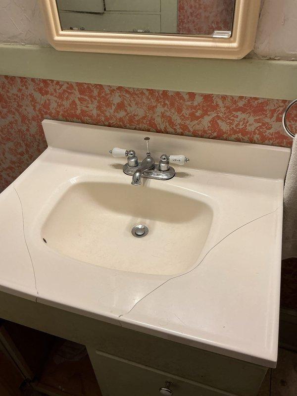 Replaced customer's bathroom sink assembly after previous DIY attempt caused damage. Installed owner-provided granite countertop with undermount ceramic sink, new Moen lavatory faucet, shut-off valves, and supply lines. Corrected issue with spinning shut-off valves that prevented proper water control to the fixture.