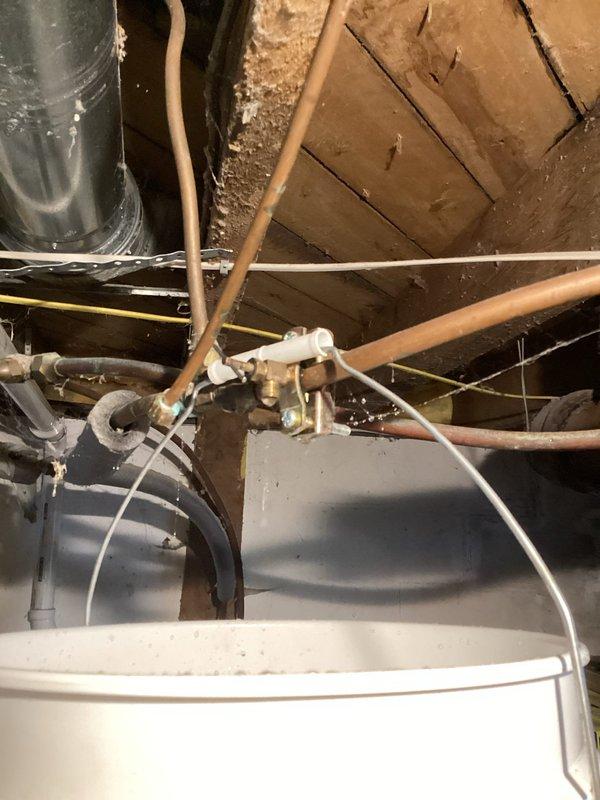Responded to service call for a leaking piercing valve on a 3/8" hot water line that was failing to shut off after HVAC contractor removed an old humidifier. Removed the defective piercing valve and repaired the damaged section of copper piping using a SharkBite coupling to restore proper system operation.