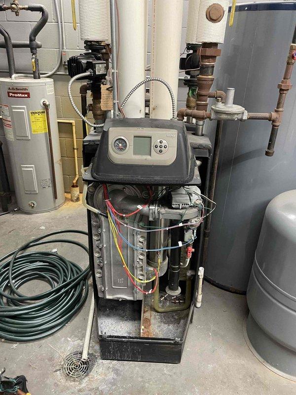 Responded to no-heat call for 13-year-old boiler system with intermittent operation issues. Diagnostic testing revealed gas valve faults on both boilers, which were short cycling and losing flame signal during low modulation. Inspection of the more problematic unit showed severely plugged heat exchanger and damaged burner door gasket. Recommended boiler tune-up and Ultra maintenance with gasket kit. Left problematic boiler disabled due to safety concerns from missing gasket components and potential flue gas leakage. Customer requested email estimates before proceeding with repairs.