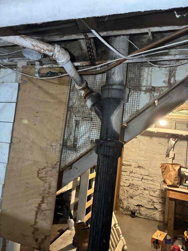 Responded to customer report of toilet leaking from stack originating from upper level. Visual inspection revealed water damage and leaks at cast iron drain pipe and PVC connections in basement area. Successfully pulled and reset toilet to resolve the issue, which was the only toilet in the residence.