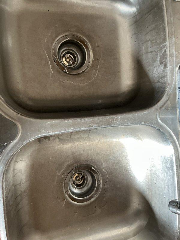Responded to service call for kitchen sink with leaking strainers. Upon inspection, discovered deteriorated drain components with significant debris accumulation in upper third of pipes. Replaced both kitchen sink strainers, installed new continuous waste assembly, and fitted new P-trap to resolve leakage issues and restore proper drainage function.