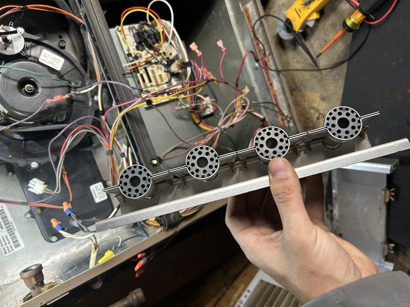 Replaced four-burner assembly in gas furnace due to oxidized and deteriorated condition of original components. Removed existing burner assembly, installed new burner units, and verified proper ignition and flame operation. System now functioning within normal parameters.