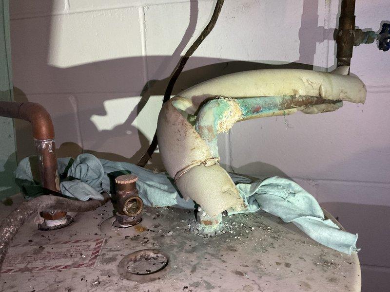Responded to service call for water leak affecting septic system. Upon inspection, identified significant blue-green corrosion on copper piping at joint connection in utility area. Found deteriorated pipe insulation with visible water damage and worn yellow insulation on connecting lines. Replaced corroded section and installed new fittings to resolve the leak.