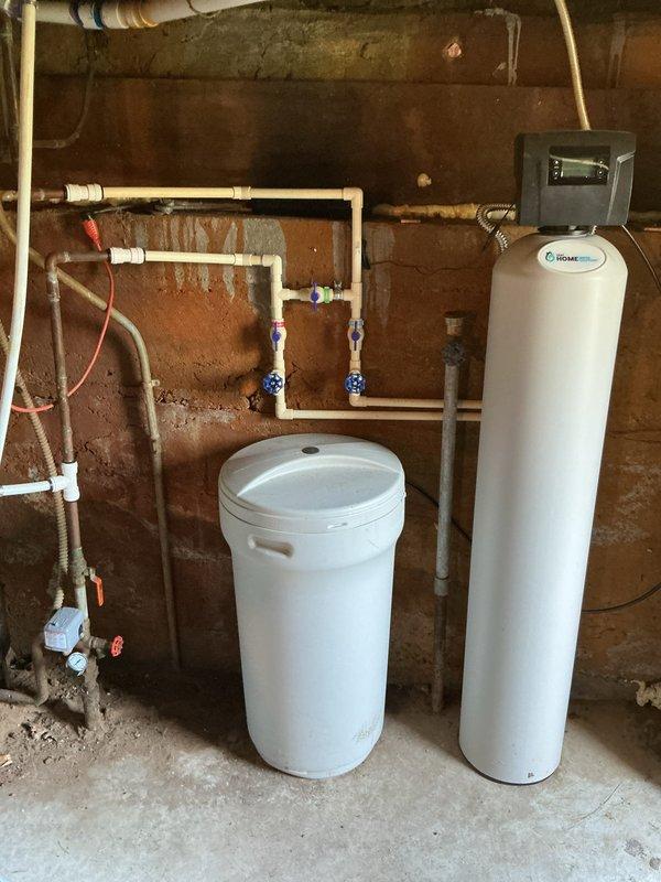 Found water softener draining improperly into non-connected ground pipe. Redirected discharge into nearby existing standpipe to establish proper drainage connection to sanitary system, resolving overflow issue.