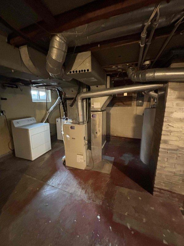 Completed diagnostic inspection of basement utility area. Evaluated gas line connections to kitchen stove, dryer, and furnace. Identified leak under kitchen sink and assessed garbage disposal installation requirements. Photos documented the mechanical room layout showing existing HVAC system, ductwork, and gas line configuration for reference during future service calls.