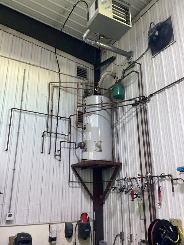 Responded to no heat complaint in repair and wash bay areas. Diagnosed low water level in hydronic heating system, replenished water and bled air from zones. System restored to operation with pumps functioning, though some residual air remains in lines which may self-resolve. All zones now receiving heat, but may require follow-up bleeding if heating issues persist.
