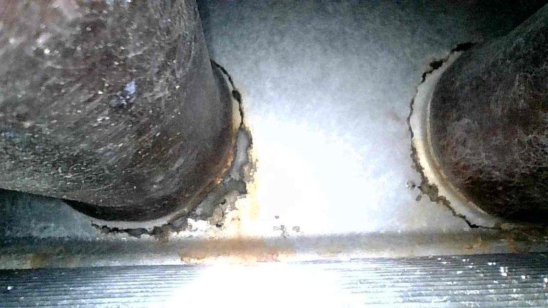 Responded to no heat call for 20-year-old furnace. Diagnosed control board failure preventing inducer motor startup. Further inspection revealed severely compromised heat exchanger with significant corrosion, visible holes and cracks in the back header. Documented damage with photos, tagged system as unsafe for operation, and scheduled follow-up consultation with customer.