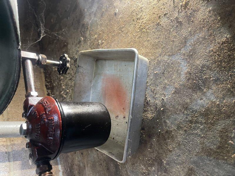 Inspected leaking valve at bottom of customer's fuel oil tank that was previously identified during tune-up service last month. Observed increased dripping since tank was recently filled. Tightened valve nut and cleaned oil residue. Informed customer that complete valve replacement would require emptying the tank first, as the valve is approximately 60 years old.