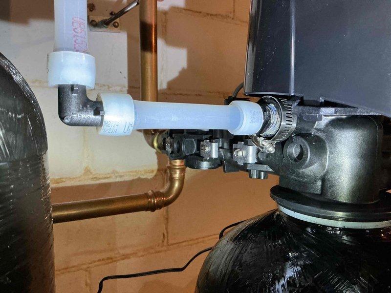Replaced failed factory-supplied threaded drain adapter on water treatment system that was causing a leak. Service required 1 hour to complete installation of new adapter, resolving the issue and restoring proper function to the system.