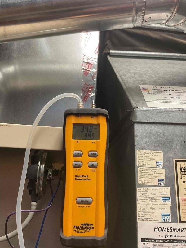 Performed furnace tune-up on natural gas system. Identified humming inducer motor and aging hot surface ignitor with low output. Replaced ignitor due to age. Conducted pressure testing with dual-port manometer, readings at 378/375. Noted moisture/water damage on adjacent wall structure requiring attention.