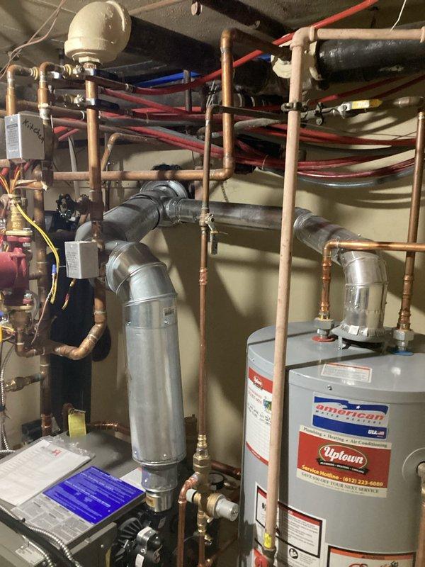 Inspected recently installed boiler following customer complaint of excessive operational noise audible from first floor living space. Observed cast iron boiler with inducer motor emitting vibration. Determined that shared venting configuration with water heater and inadequate support structure is causing noise transmission through the system. Recommended separation of boiler venting from water heater and installation of improved vibration isolation supports to resolve the issue.