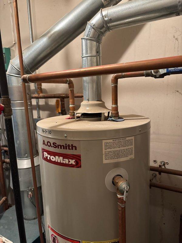 Replaced corroded 15-year-old LP water heater with new A.O. Smith ProMax model to prevent potential leaking. Installation included proper connection of copper supply lines and venting system in utility room. Customer declined recommendation for assessment of potential combi boiler unit that could service both domestic water and existing boiler system.