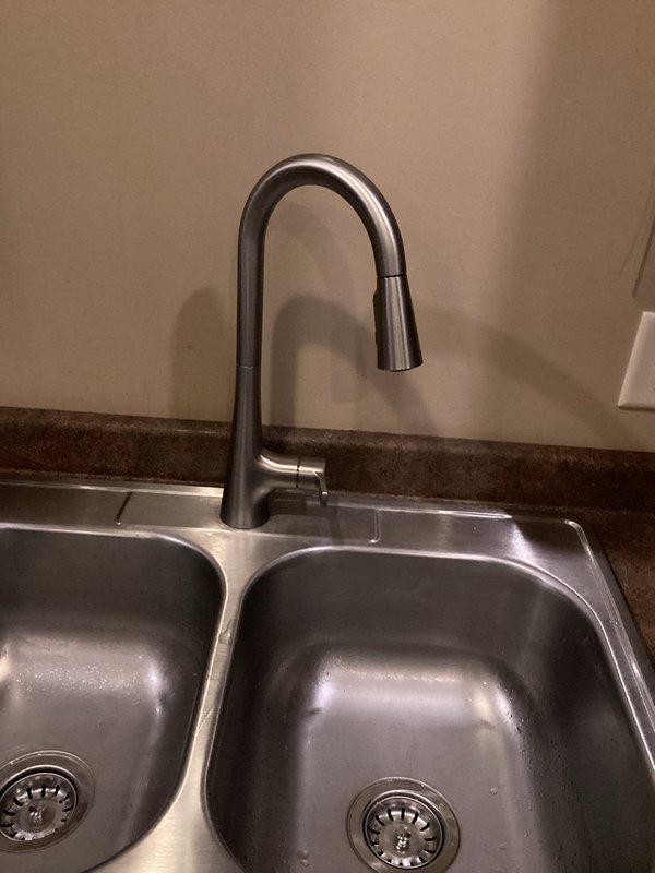 Installed customer-supplied bathroom vanity faucet and kitchen faucet per specifications. Completed P-trap assembly with proper drain connections and installed flexible supply lines. No warranties provided on customer-supplied materials as per company policy.