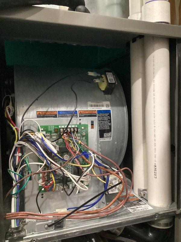 Responded to a no-heat service call for a downflow furnace that was cycling on but shutting down prematurely due to pressure switch issues. Identified water in the inducer assembly caused by a condensate line clogged with PVC shavings from installation. Cleared the blocked drain lines, removed water from inducer, and restored normal heating operation. Discussed future improvements including new lineset installation for AC issues, thermostat relocation, and proper mini-split positioning in 4-season room.