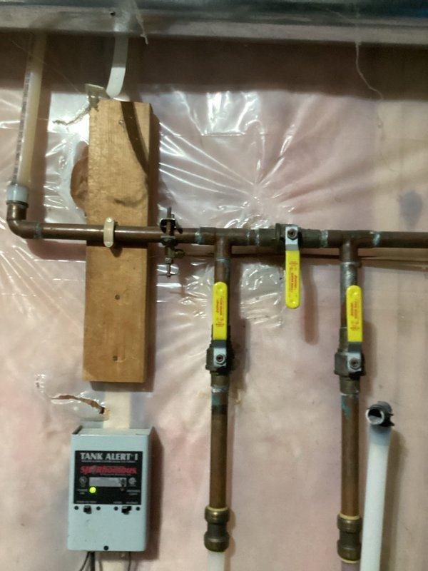 Inspected existing plumbing system to provide estimate for new humidifier valve installation. Evaluated current copper pipe configuration with multiple brass valves and examined the water heater connection to HVAC system where humidifier is mounted. Documented current setup to develop appropriate solution for valve replacement.
