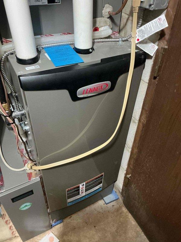 Completed warranty service on customer's 6-month-old Lennox furnace where an inspector had identified water leaking from behind the tape covering the combustion analysis hole. Removed deteriorated tape, applied new sealing tape with proper adhesion to eliminate wrinkles, and verified proper sealing. System is now functioning correctly with no moisture leakage from the combustion/exhaust components.