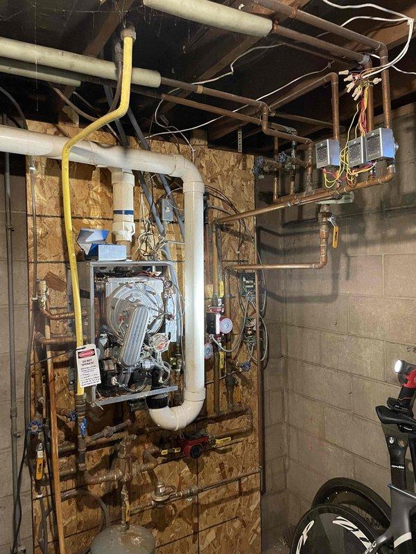 During service call to diagnose overheating boiler (installed 2006), identified a stuck zone valve causing the main floor zone to overheat. Visual inspection revealed exhaust leaking around seams and burner door. Combustion analyzer detected CO levels up to 30ppm throughout the area. Red-tagged boiler as unsafe due to exhaust leakage into home. Noted system requires zone valve replacement and control updates. Advisor scheduled to evaluate repairs.