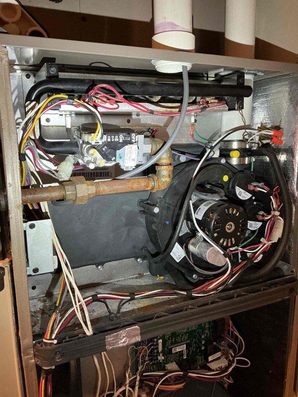 Responded to no heat complaint on 7-year-old Luxaire furnace. Diagnosed system with only one burner igniting during heat call. Upon inspection of burner assembly, found low fire side of gas valve coil was open. Attempted to clean orifices but gas valve subsequently failed to operate. Recommended replacement of gas valve and burner assembly or furnace replacement as alternative solution due to deteriorated condition of burner components.