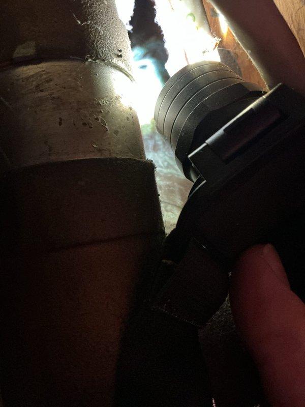 Inspected property for reported water leak and identified a worn-through cast-iron main pipe leading to septic system. Further examination revealed multiple additional leaks in overhead copper piping, with visible oxidation forming green patina on several copper lines. Due to extent of damage throughout the plumbing system, scheduled follow-up for comprehensive assessment and estimate for complete system re-pipe.