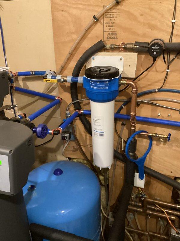 Removed and replaced old sediment filter with new 20" Point of Entry Sediment Filter Kit. Cut existing piping and installed new sediment filter system, properly connecting it to the home's water treatment setup which includes existing water softener components and pressure tank.
