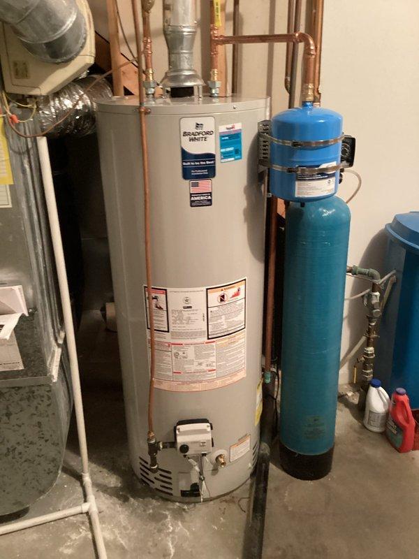 Completed installation of Bradford White water heater and blue water treatment system in basement utility area as per sold job specifications. System includes properly connected copper piping, valves and all required components. Both units were tested and confirmed to be functioning as designed.