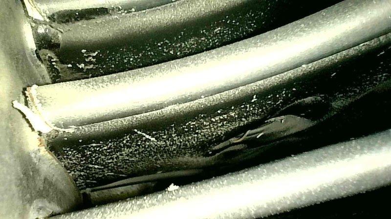 Completed maintenance check on aging furnace with unknown FRP. Discovered secondary heat exchanger beginning to leak, along with dirt buildup on heat exchanger tubes and a clogged filter. Temperature readings measured at 59/70.2. System still maintaining acceptable CO levels, but secondary heat exchanger was replaced due to age and early stage leak detection to prevent future failure.