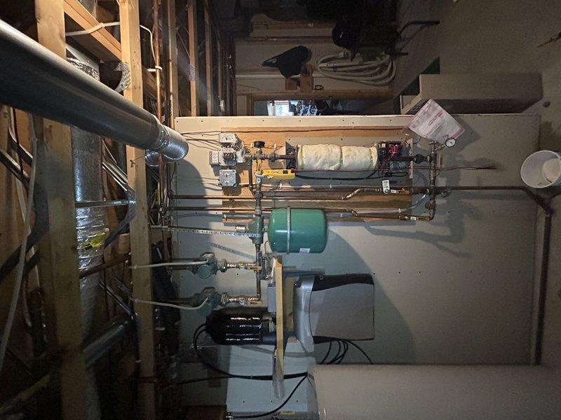 Conducted annual furnace tune-up on 25-year-old Pulse system. Performed standard maintenance including temperature rise verification, drain cleaning, electrical component inspection, and air exchanger vacuuming. Investigated electric boiler issues; system required water addition to achieve proper pressure (15+ psi). Identified potential problem with manual reset on thermostat located on top of electric boiler, likely triggered by low water condition. Discovered damaged transformer board during voltage testing that will require replacement.