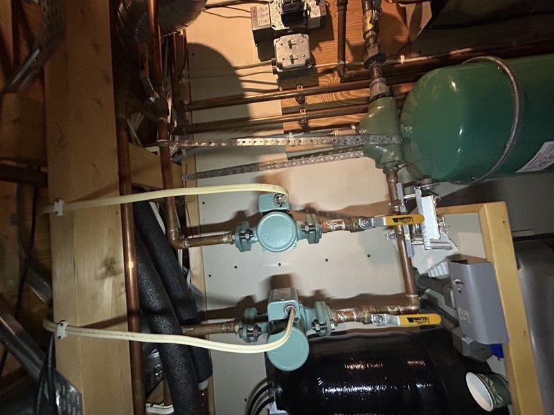 Conducted annual furnace tune-up on 25-year-old Pulse system. Performed standard maintenance including temperature rise verification, drain cleaning, electrical component inspection, and air exchanger vacuuming. Investigated electric boiler issues; system required water addition to achieve proper pressure (15+ psi). Identified potential problem with manual reset on thermostat located on top of electric boiler, likely triggered by low water condition. Discovered damaged transformer board during voltage testing that will require replacement.