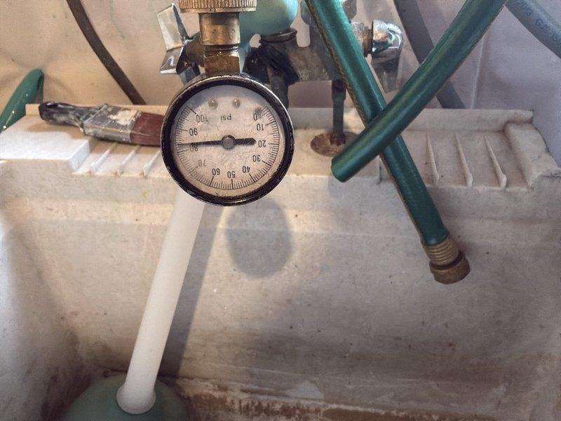 Responded to service call for water leak on 20+ year old 60-gallon natural gas water heater. Diagnostic inspection revealed tank rupture causing water to spray from the side of the unit. Pressure gauge reading showed approximately 20-30 PSI. Customer opted for complete system replacement with tankless water heater, scheduled for future installation.