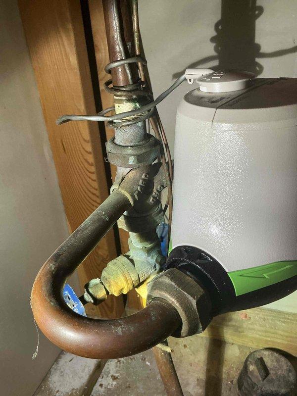 Responded to warranty service call for a leak that developed under the pressure regulator valve after previous water softener installation. Customer declined repair option to replace washers and re-tighten connections, instead requesting full replacement of the meter horn which was leaking at connection to water meter. Replaced meter horn with new copper meter setter to resolve the issue.