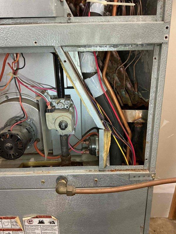 Completed furnace maintenance on 21-year-old Magic Pack unit. Inspected system for safety and reliability, finding properly functioning blower motor with clean wheel and strong flame sensor, ignitor, and draft motor. Noted capacitor below specification and detected severe rust with potential pinholes in heat exchanger visible through burner inspection. Scheduled service advisor to discuss replacement options due to heat exchanger integrity concerns.