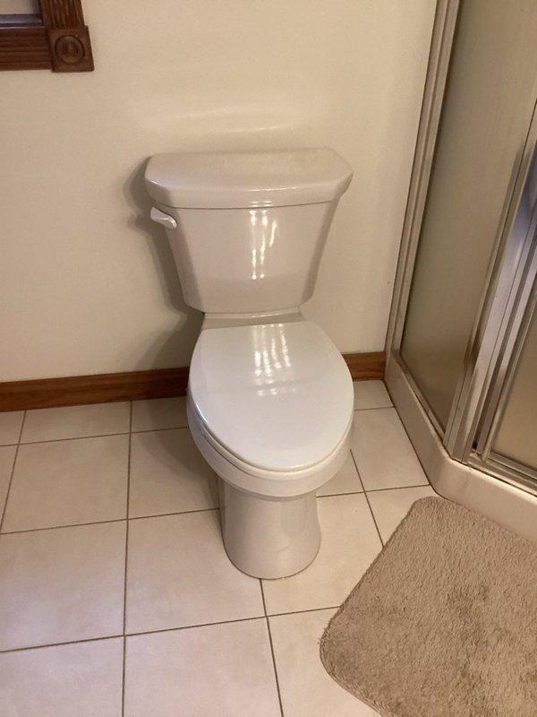 Installed new comfort height toilet as requested during scheduled return service. Completed installation of two-piece porcelain toilet against wall, ensuring proper positioning on the ceramic tile flooring. Job completed within allocated 2-hour timeframe.