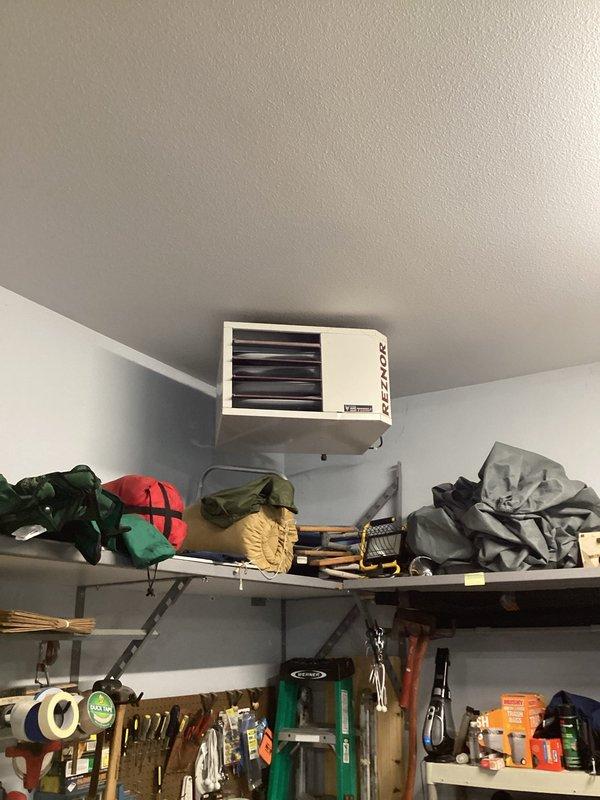 Responded to no-heat complaint for 10-year-old Reznor garage unit heater. Diagnostic testing revealed low battery warning on Honeywell thermostat. Replaced two AA batteries in thermostat which resolved the issue completely, restoring normal operation to the heating system.