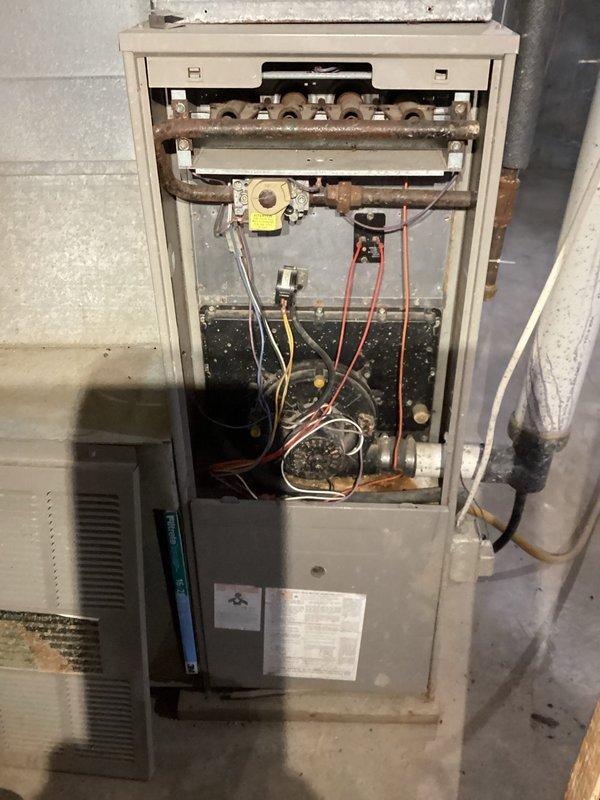Performed diagnostic inspection on LP furnace with no heat complaint. Identified multiple critical issues: control board failure (no power to combustion blower), severely plugged burners, and cracked heat exchanger beneath burner inlet. Tagged unit out of service due to safety hazards. Customer advised of findings and scheduled for replacement consultation due to age and condition of equipment.