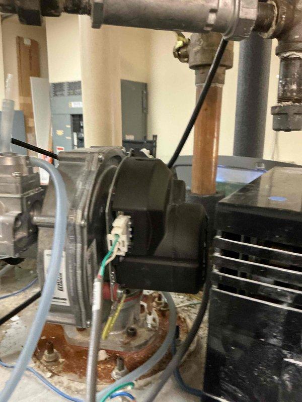 Diagnosed Cyclone MXi Modulating water heater displaying "No Blower Speed Feedback" error code resulting in no hot water for kitchen. Identified seizing blower motor assembly as the root cause and temporarily restored operation. Motor exhibited rough operation upon restart, indicating imminent failure. Parts ordered for complete repair.