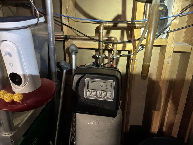 Inspected 21-year-old water softener system due to operational failure where salt was remaining in the brine tank with no water present. Diagnostic testing revealed the control head was not cycling properly and water hardness measured at 22 grains. Recommended full system replacement as optimal solution, but customer opted for repair of control head. Advised customer that resin bed is likely compromised and may not produce adequately softened water even with new control head. Parts will be sourced from Robert Hill.