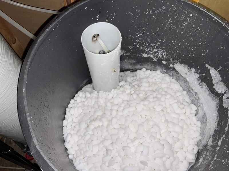 Inspected 21-year-old water softener system due to operational failure where salt was remaining in the brine tank with no water present. Diagnostic testing revealed the control head was not cycling properly and water hardness measured at 22 grains. Recommended full system replacement as optimal solution, but customer opted for repair of control head. Advised customer that resin bed is likely compromised and may not produce adequately softened water even with new control head. Parts will be sourced from Robert Hill.