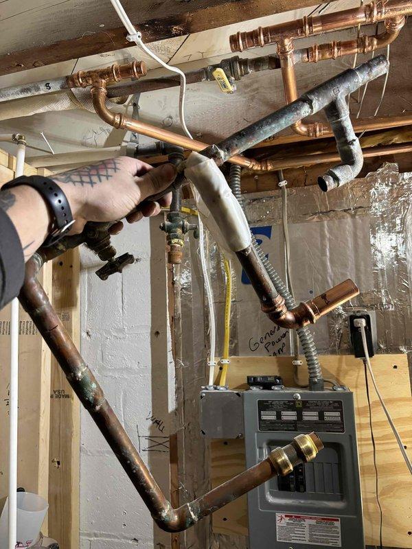 Replaced deteriorated outdoor hose bib and remediated leaking copper piping in the plumbing system that was causing water intrusion between floors. Cut out damaged copper section, installed new piping connections, and secured a loose toilet with silicone sealant to prevent further leakage issues.