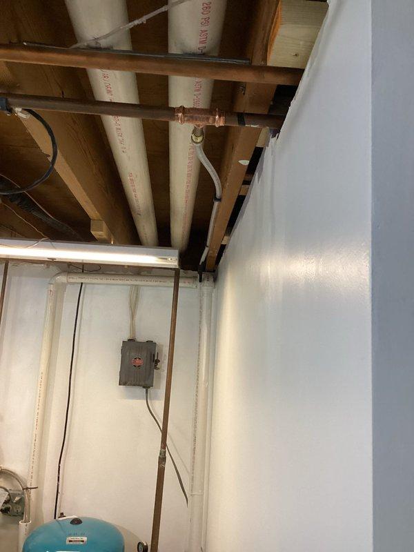 Completed installation of customer-supplied pedestal sink and toilet in bathroom, which included properly connecting water supply lines, drain pipes, and ensuring secure fixture mounting. Installation required accessing ceiling plumbing in utility area to properly route PVC drainage and copper water supply lines for the new bathroom fixtures.