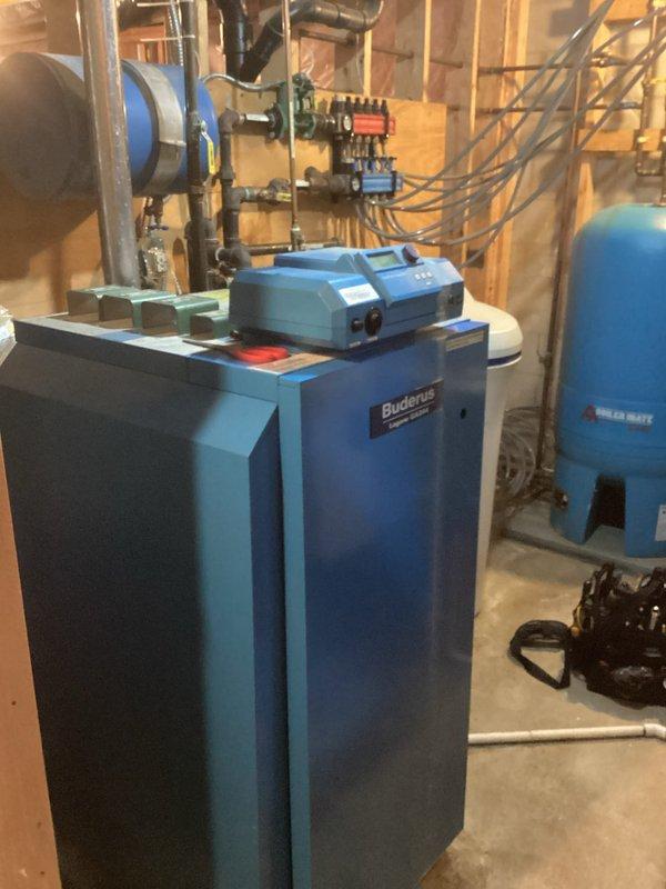 Diagnosed and resolved restricted flow issue on German Buderus boiler system with multiple loops. System was low on water, affecting garage in-floor heating; added water to restore flow and purged significant air from system. Left air vent open on manifold for continued degassing and advised customer to monitor system pressure and consider future replacement of this complex boiler system with automatic mixing valves.