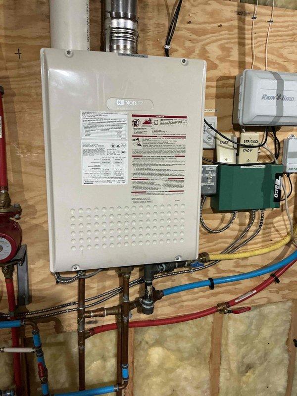 Inspected Noritz tankless water heater due to reported reduced output. Confirmed system requires descaling service but lacks proper isolation valves needed for flushing procedure. Also examined Mansfield toilet (Model 160) with reported intermittent leaks at handle and base; observed mineral buildup in tank. Submitted parts order form for toilet repair components and provided estimate for necessary water heater valve installation to enable proper maintenance.