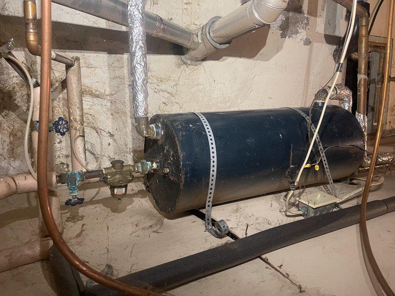 Responded to emergency no-heat call where customer reported smoking and flames inside their aging boiler. Investigation revealed combustion issues caused by insulation material that had been pulled into the burner orifice area by a rodent, preventing proper burning. Removed insulation debris, performed standard boiler service, and cleaned flame sensor to restore proper operation. System functioning normally upon departure but recommended replacement of pilot assembly if intermittent pilot issues persist.