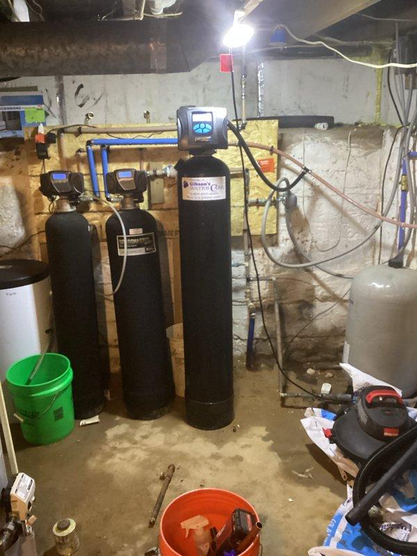 Replaced leaking A.O. Smith ProLine water heater under warranty after diagnosing unit failure. Original 5-year-old unit was leaking from bottom and not producing hot water. Complete installation included reconnecting all necessary copper and PVC piping with appropriate fittings and valves in basement utility area where water treatment system is also located.