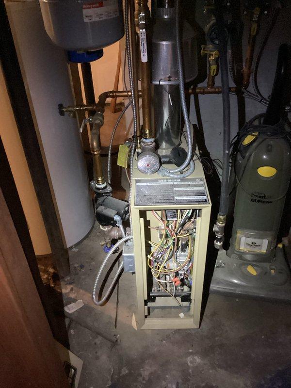 Diagnosed low pressure issue in aging boiler system causing intermittent heating failure. Discovered malfunctioning backflow preventer preventing proper operation of the auto fill valve. Manually cleared the stuck backflow preventer to restore water flow, properly pressurized the system, and restored heat to the residence. Documented need for replacement of both backflow preventer and auto fill valve as recommended repair.