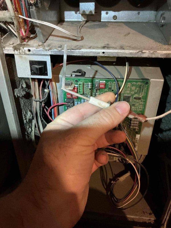 Performed diagnostic assessment on 19-year-old furnace with suspected smoke damage following a house fire. Inspection revealed smoke contamination inside front cover, potential heat exchanger crack, severely smoke-damaged condensate pan and evaporator coil, grinding draft motor, and worn flame sensor and ignitor. Documented damage with photographic evidence of electrical components and control board for insurance purposes.