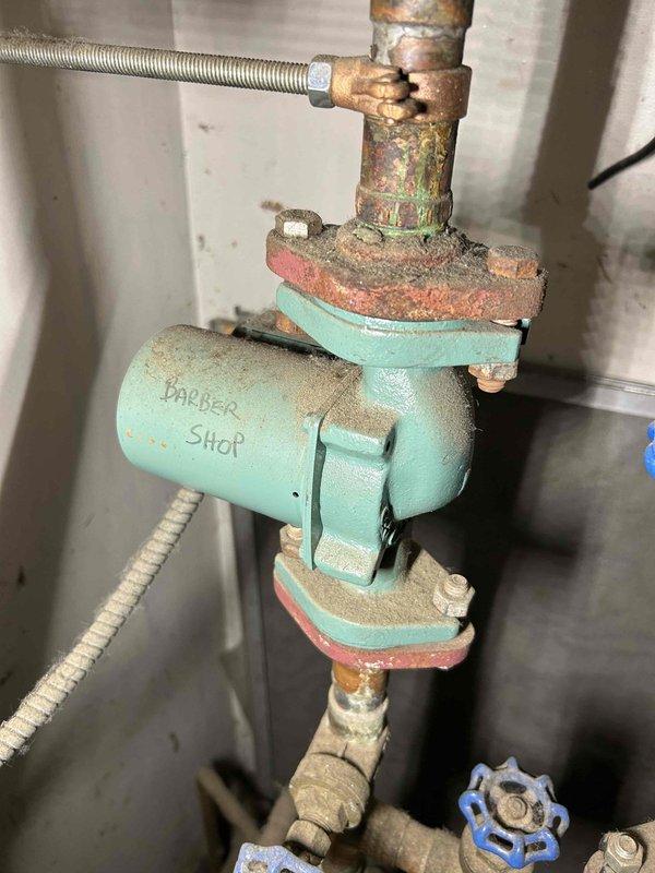Diagnosed no heat complaint on upper level of commercial property. Investigation revealed excessive heat in mechanical room (80°+) affecting thermostat reading in nearby main living area, preventing boiler activation for outer rooms. Confirmed system functionality by manually setting thermostat to 90° which successfully activated boiler and heated registers. Recommended installation of ventilation/exhaust fan in mechanical room to prevent heat transfer to living space and scheduled follow-up with Russ to implement solution.